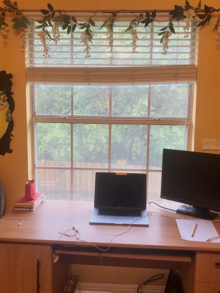 desk with laptop in front of window