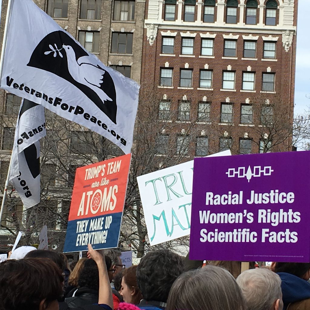 photo of signs at a rally/march for racial justice and women's rights